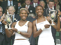 Serena and Venus Williams hold their trophies after winning the women�s doubles championship on the centre court at Wimbledon on Sunday. 