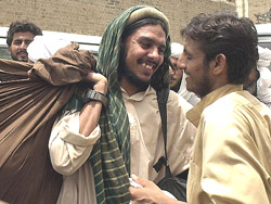 A Pakistani Islamic militant (L) is greeted by a friend after his release