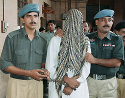 Policemen escort Pakistan Rangers inspector Waseem Akhtar on the premises of an anti-terrorism court in Karachi on Wednesday.
