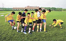Chinese soccer students practise at the BTV Sangao Soccer School on the outskirts of Beijing on Tuesday.