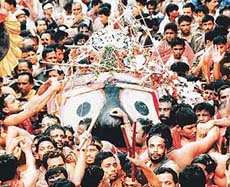 Devotees carry an idol of Lord Jagannath during a religious procession in Puri, Orissa, on Friday.