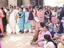 Students and their parents await their turn to submit examination forms outside the office of the District Head of the Punjab School