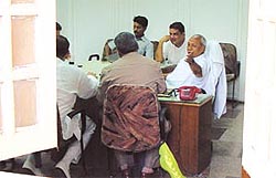Industries Minister Deep Chand Bandhu entertaining journalists and MLAs in his office at the Old Secretariat after a power cut forced him to retreat to his room