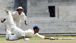 UAE fielder Atif Ali looks on as Nepalese batsman Parash Luniya dives back to the crease 