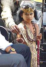 Arjun, a six-year-old boy, dressed as Hindu God Shiva begs on a street