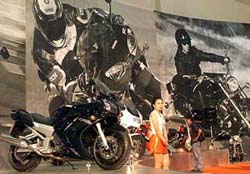 An Indonesian woman stands in front of a display of Yamaha motorcycles