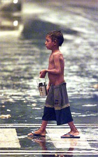 A child walks through the rain