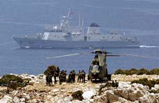 Spanish soldiers stand near a helicopter as their navy warship patrols by the disputed Perejil island, claimed by Morocco and Spain on Saturday
