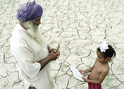 A farmer prays with his grandson