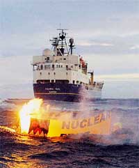Greenpeace activists set fire to a banner reading "nuclear-free Pacific"