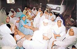 Women mourn the death of four villagers who died in an accident in the USA