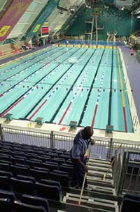 A cleaner sweeps the grandstand at the Manchester Aquatics Centre 