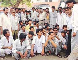 A group of labourers sit on a dharna at the Division No. 3 police station 