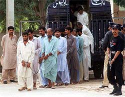 Defendants and witnesses in a gang-rape case alight from a police bus