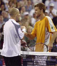 Andre Agassi is congratulated by Brazilian Gustavo Kuerten