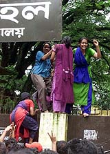 Bangladeshi students try to scale the wall 