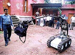 A policeman demonstrates the  hi-tech remote-control robot 