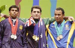 Australia's gold medalist Yourik Sarkisian is flanked by India's Krishnan Madasamy and Marcus Stephen