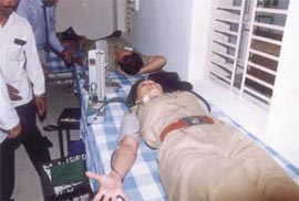 A lady officer donates blood at a camp