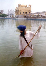 A Sikh sewadar cleans the holy pool