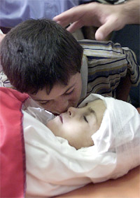 The brother of nine-year-old Asma Ahmed bids farewell to her sister