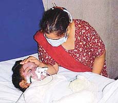 Manpreet Singh with 52 per cent burns, with his mother at GMCH.