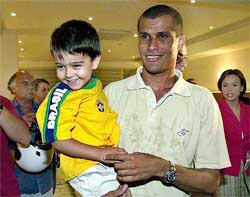 A.C. Milan's Brazilian soccer player Rivaldo picks up an unidentified boy