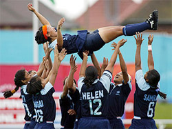 Members of the India women's hockey team toss captain Surja Waikhom