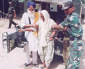 Surjeet Kaur is helped by Army officials at the Army medical camp held in Chack Ruldu Singh Wala village