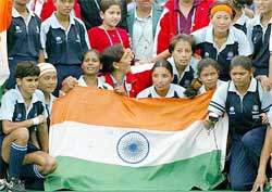 Indian players celebrate with a flag after defeating England
