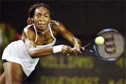 Venus Williams of the United States returns a backhand 