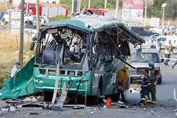 Israeli policemen search a bus which was destroyed in an explosion