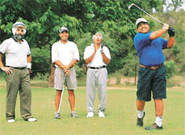 Ashok Malhotra completes the swing as Arjuna awardee Harmeet Kahlon (second from left) looks on 
