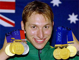 Australia's Ian Thope, draped in an Australian flag, wears the six gold and one silver medal 