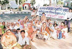 Women protesters stage a dharna in front of the Dera Bassi police station against alleged high-handedness of police officials on Tuesday.