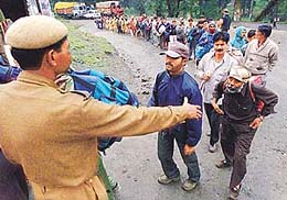 A CRPF jawan urges pilgrims to form a queue for a security check en route the holy cave of Amarnath in Chanderwari on Wednesday.