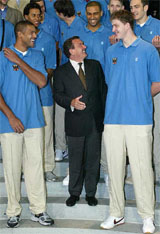 German Chancellor Gerhard Schroeder stands between basketball players