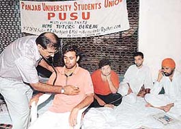 A doctor examines an activist of the Panjab University Students Union on fast at Student Centre