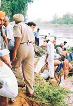 Villagers plug the 20 feet wide breach in the Sirhind Canal