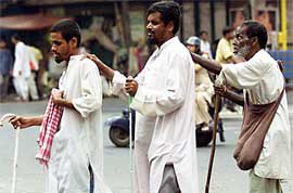Three blind men help each other cross a busy road