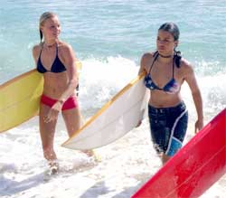 Actresses Kate Bosworth and Michelle Rodriguez carry their surf boards