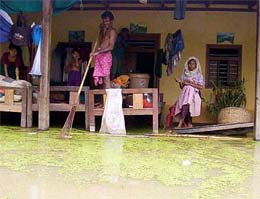 A resident tries to catch fish inside his submerged house