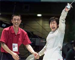Chinese Tan Xue celebrates with her coach after winning the women's foil final 