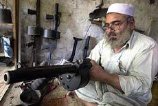 A Pakistani tribesman makes a grenade launcher at his small roadside shop in the Darra Adam Khel tribal area, 47 km south of Peshawar, on Monday
