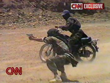 A man fires a weapon while another rides a motor cycle nearby in an excerpt released by cable TV channel CNN on Wednesday