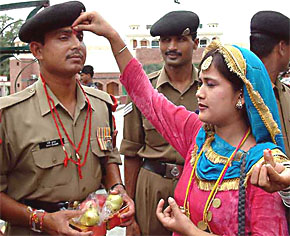 A student applies 'tilak' to a BSF jawan