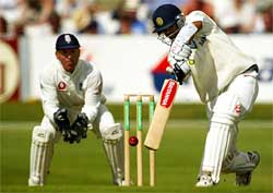 India's Rahul Dravid hits out while England's wicketkeeper Alec Stewart looks on 