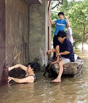 Chinese residents retrieve belongings from a flooded house