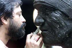 Indian sculptor Dipankar Dutta works on a statue