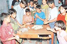 Slum kids learn cooking from a Shivalik View chef at a special canteen set up for them by CITCO 
